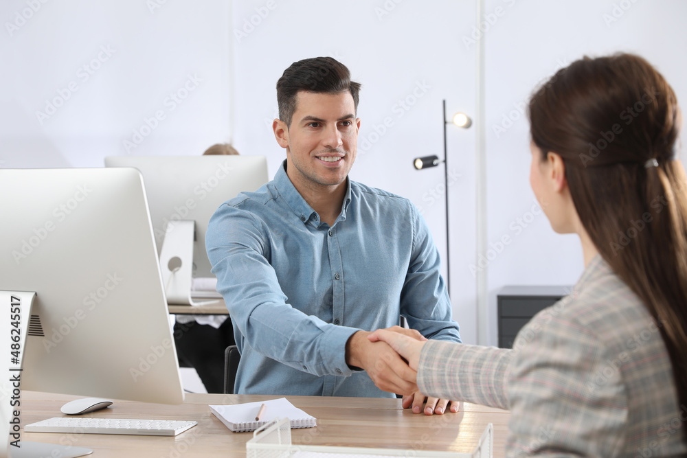 Employee shaking hands with intern in office
