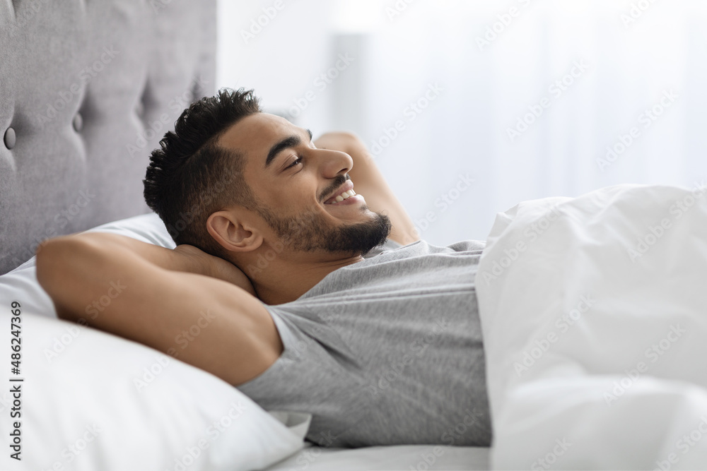Morning Relax. Smiling Pleased Arab Man Lying In Bed After Waking Up Morning Relax. Smiling Pleased Arab Man Lying In Bed After Waking Up