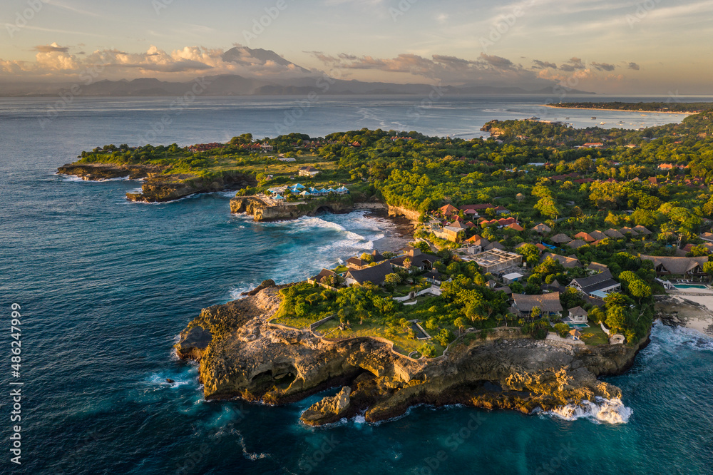 Stunning sunset over the Nusa Lembongan island devil's tear coast with the Bali Agung volcano in the background in Indonesia, Southeast Asia