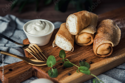 Pancakes with cottage cheese on a wooden plate