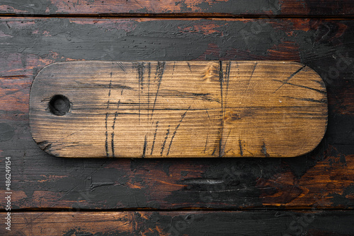 Empty wooden cutting board, top view flat lay , with copy space for text or your product, on old dark wooden table background