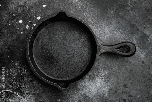 Empty frying pan with copy space for text or food with copy space for text or food, top view flat lay , on black dark stone table background photo
