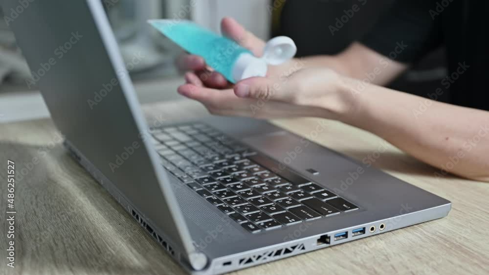 Man hand rubbing with alcohol gel and scanning fingerprint with typing on laptop at home Man hand rubbing with alcohol gel and scanning fingerprint with typing on laptop at home