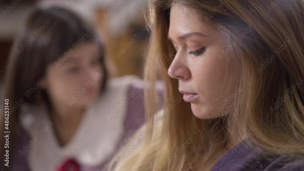 Side view close-up sad beautiful woman talking arguing with blurred friend at background. Portrait of upset Caucasian millennial lady quarreling indoors. Misunderstanding and conflict concept Side view close-up sad beautiful woman talking arguing with blurred friend at background. Portrait of upset Caucasian millennial lady quarreling indoors. Misunderstanding and conflict concept