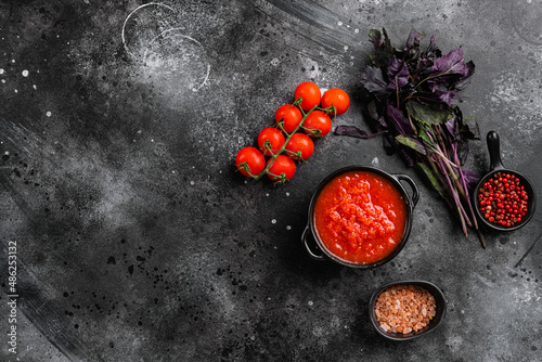 Homemade tomato sauce passata  traditional recipe of italian cuisine, on black dark stone table background, top view flat lay, with copy space for text