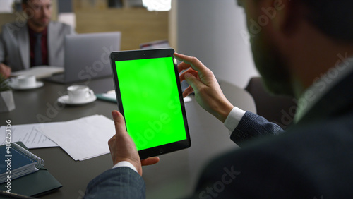 Financial worker browsing tablet green screen searching web in business centre.