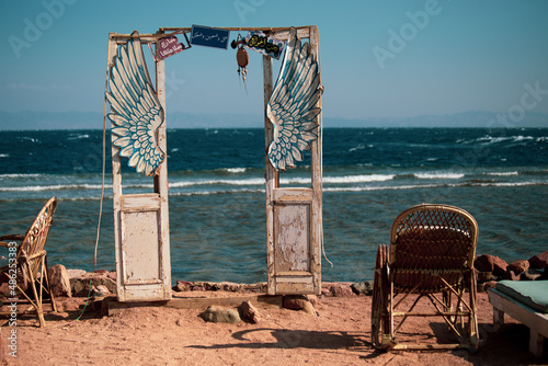 Fotografie Creative decoration in the seaside cafe in Dahab: old wooden doors and wings in