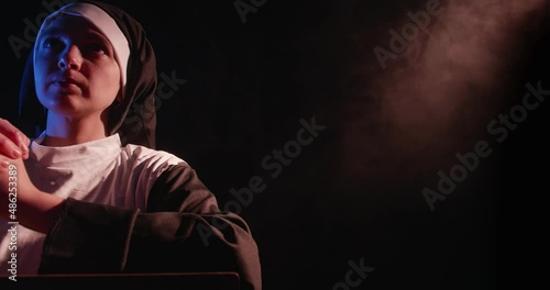Nun Praying In A Dark Smokey Room
