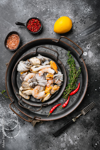 Raw seafood mussels, squid octopus, on black dark stone table background, top view flat lay
