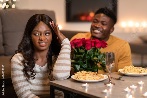 Discontented Black Woman Expressing Disgust While Boyfriend Giving Flowers Indoors