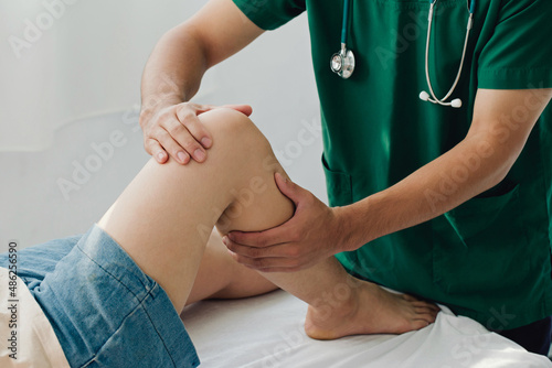 Consultation therapist with the treatment of treating injured knee of the patient with his therapist in clinic, sport physical therapy concept,