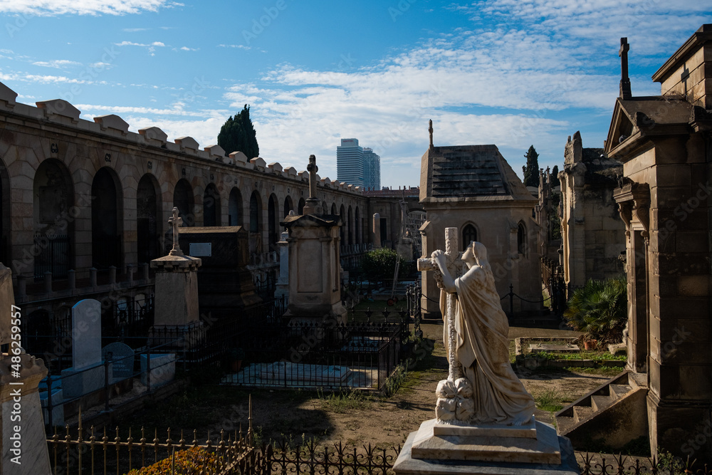 View of Poble Nou cemetery on a sunny day with historical statues and graves, with crosses and christian symbols and flowers. concept of death in Barcelona, Spain - 1 November 2021