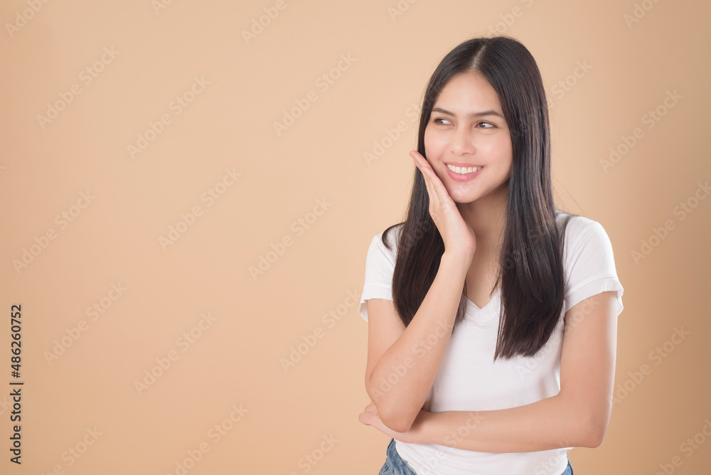 A Portrait of Asian woman with white T-shirt over Light brown background studio A Portrait of Asian woman with white T-shirt over Light brown background studio