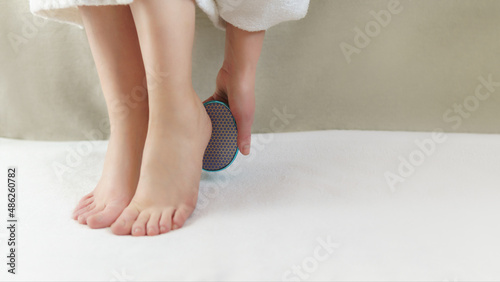 Adult woman scrubbing sole of her foot.