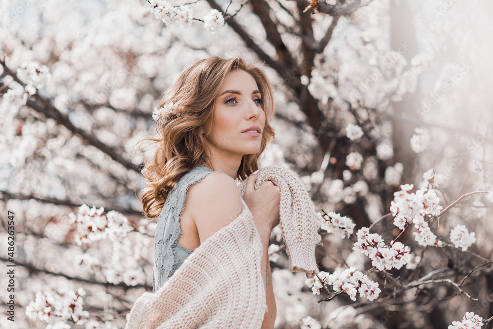 Portrait of pretty blong girl posing against the spring blooming trees in the garden. Portrait of pretty blong girl posing against the spring blooming trees in the garden.