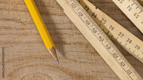 Measuring stick and a pencil on an old wooden table