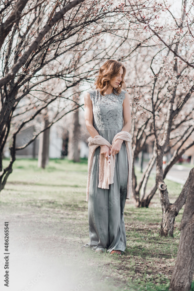 Portrait of pretty blong girl posing against the spring blooming trees in the garden. Portrait of pretty blong girl posing against the spring blooming trees in the garden.