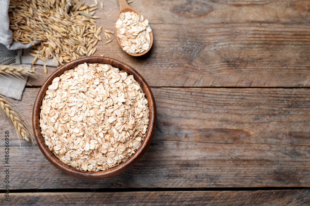 Bowl with oatmeal on wooden table, flat lay. Space for text Bowl with oatmeal on wooden table, flat lay. Space for text