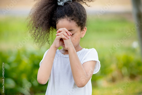 little girl praying happy relax in weekend holiday lifestyle park outdoor nature background.