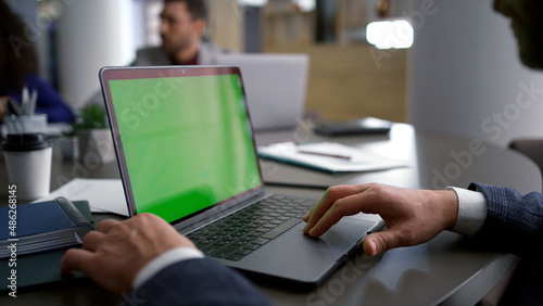 Entrepreneur man searching laptop green screen on diverse business team meeting. © stockbusters