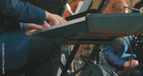 Close up of man hands playing a synthesizer at a concert. The concept of live, musical performance and virtuosity of playing a keyboard musical instrument
