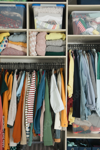 Wardrobe closet with different stylish clothes and home stuff. Fast fashion