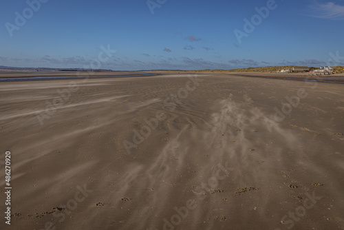 Wind blowing the sand along the beach at Camber Sands  East Sussex  England