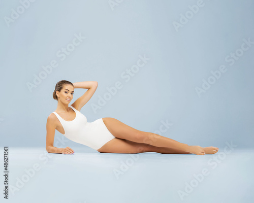 Slender and healthy girl in a white swimsuit or underwear. Young woman with perfect skin. Body care, weight loss, fitness and dieting.