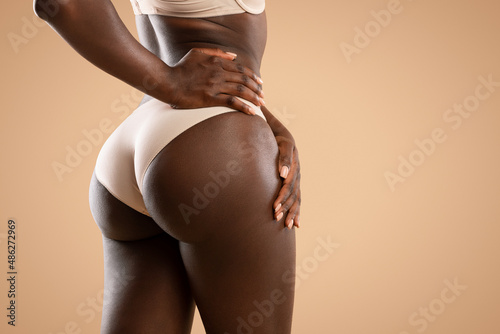 Dark skinned lady showing smooth skin on her sexy buttocks photo