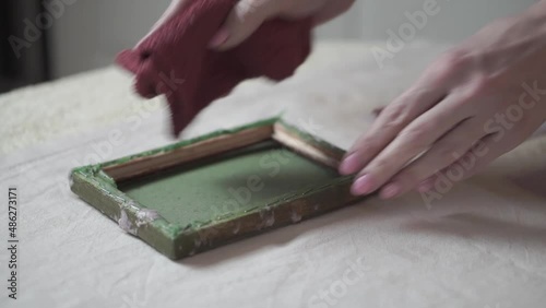 A woman holding a frame for making paper sheets from recycled paper. Selective focus. Household hobby, paper recycling. The concept of zero waste, recycling, ecology