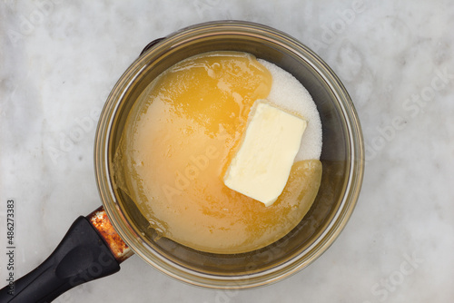 Tableau sur toile Bain-marie with sugar, butter and honey on saucepan