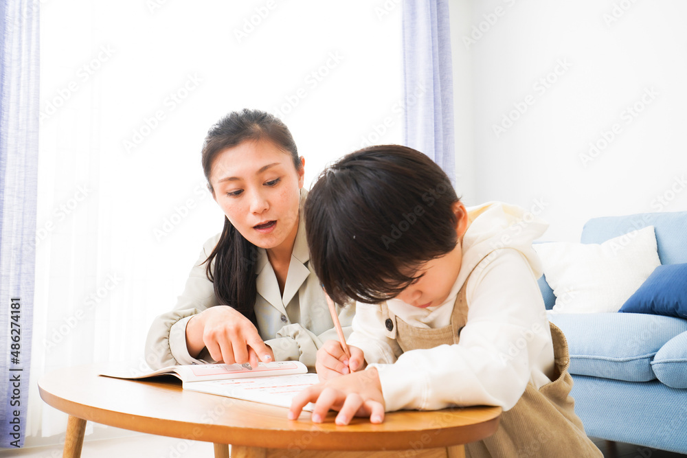 家でお母さんと一緒に勉強をする男の子 家でお母さんと一緒に勉強をする男の子