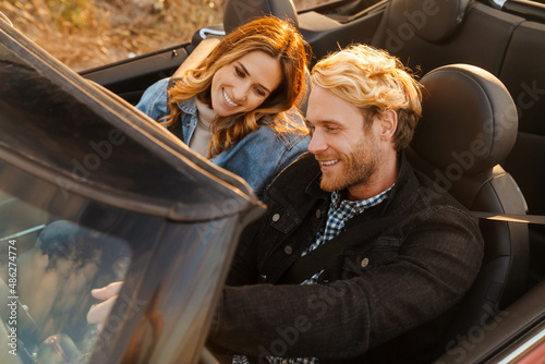 White couple smiling together while driving in car during trip photo