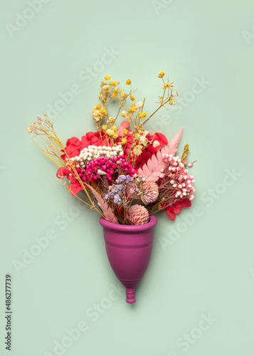 Silicone menstrual cup with flowers.Female intimate alternative gynecological hygiene concept photo
