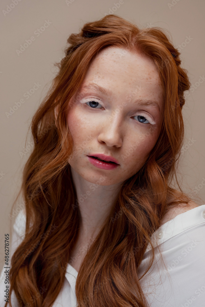 Fashion Portrait of redhead young woman with white extended eyelashes and wavy hair. Concept romantic makeup skin care Fashion Portrait of redhead young woman with white extended eyelashes and wavy hair. Concept romantic makeup skin care