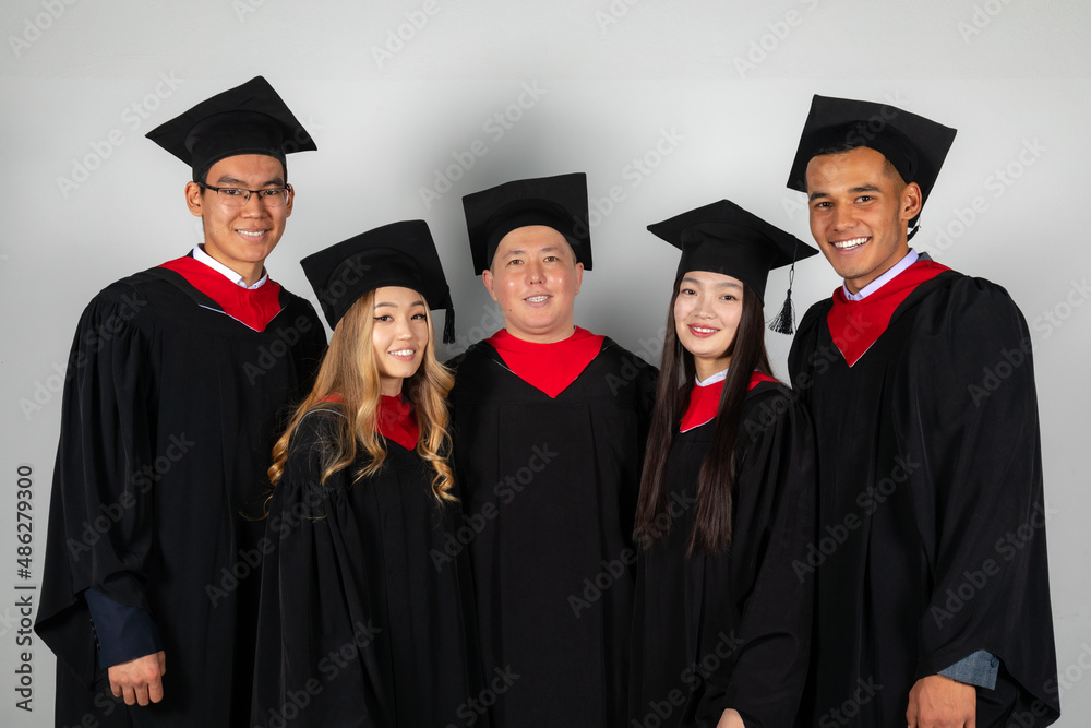 Group of graduate students friends pose together excitedly Group of graduate students friends pose together excitedly