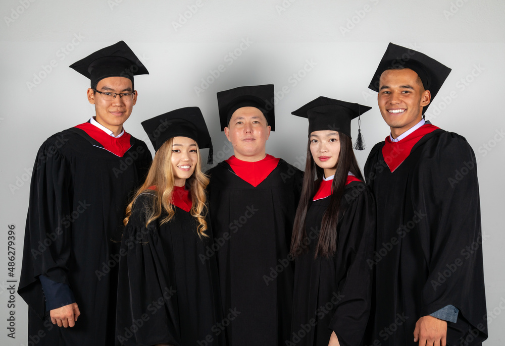 Group of graduate students friends pose together excitedly Group of graduate students friends pose together excitedly