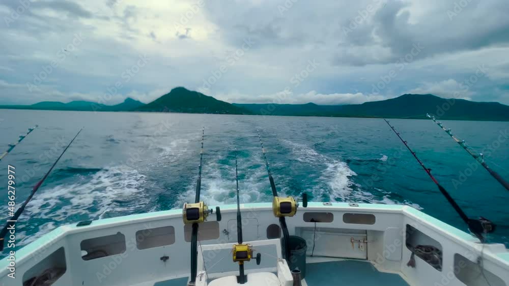 Point of view POV close shot from back of a yacht in deep ocean. Big game fishing reel in natural setting