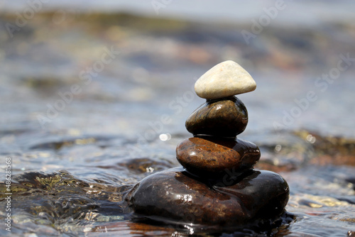 Tower of pebble stones on blurred background of the sea waves. Beach vacation  balance and relax concept