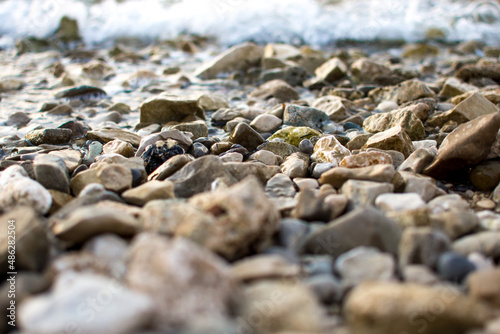 Fototapeta Naklejka Na Ścianę i Meble -  Pebbles on beach and  calm the sea, close up view. Summer holidays, vacation concept.