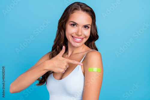 Photo of lovely brunette hairstyle lady point vaccine on hand wear teal top isolated on blue color background