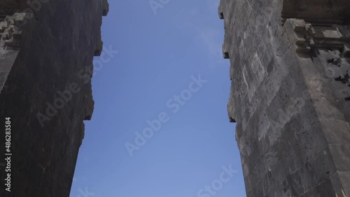 Panoramic view of calm woman praying near the historical holy oriental Bali gates with in Indonesia 