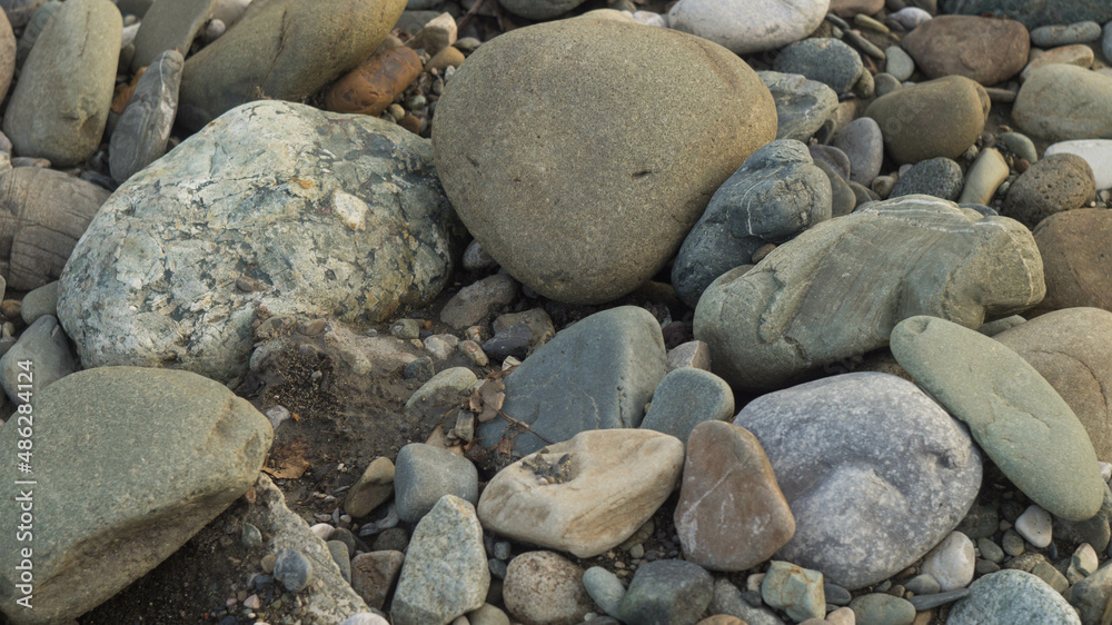 Large and small stones on the bank of the mountain river, background Large and small stones on the bank of the mountain river, background