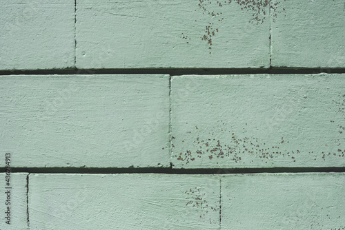 Close-up, turquoise wall with a block of bricks.