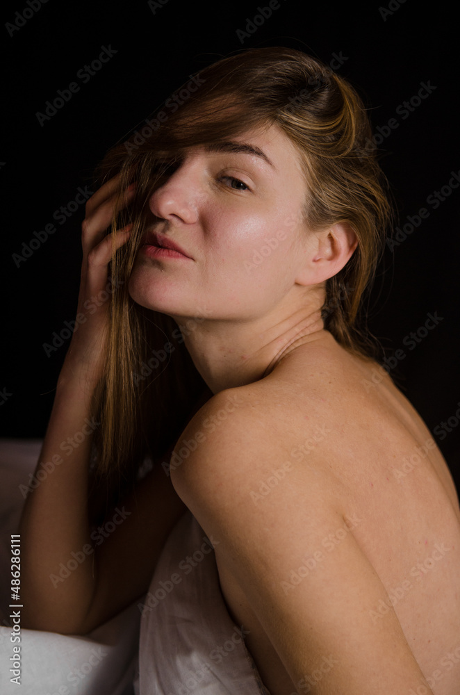 Portrait of a beautiful slender young woman with blonde hair in a white bed in beautiful aesthetic poses Portrait of a beautiful slender young woman with blonde hair in a white bed in beautiful aesthetic poses