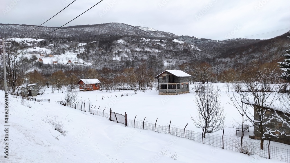 View of houses in a small Bosnian village in a snowy winter.