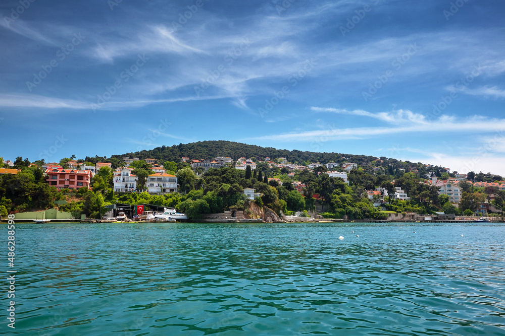 View of the sea and the coast of the island with residential buildings. Travel to Buyukada, Adalar, Prince Islands, Istanbul, Turkey