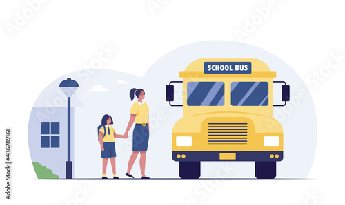 Back to school. Little girl with teacher waiting for bus at bus stop.