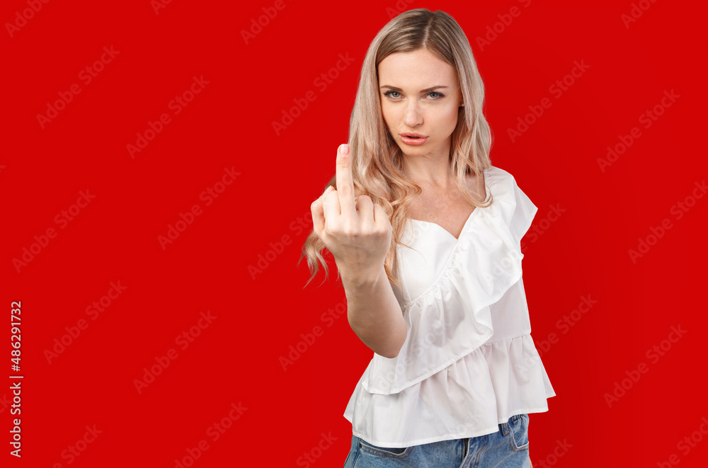 Portrait of annoyed young woman showing middle finger isolated on color background Portrait of annoyed young woman showing middle finger isolated on color background