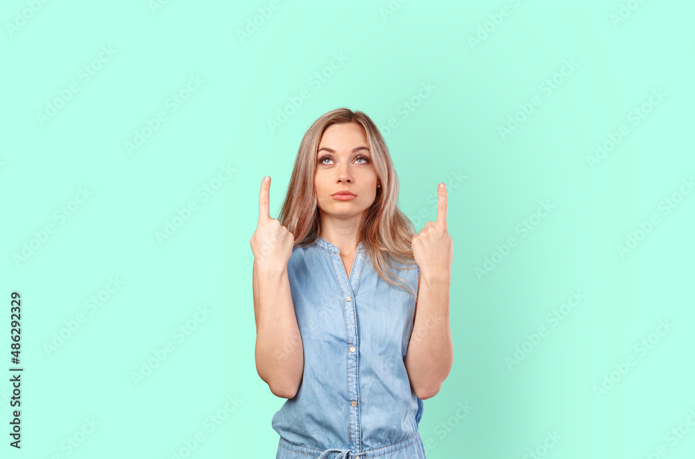 Young smiling woman pointing to copy space isolated on color background Young smiling woman pointing to copy space isolated on color background